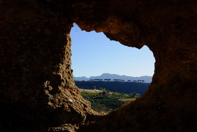 Scenic view of rock formation against sky seen through cave