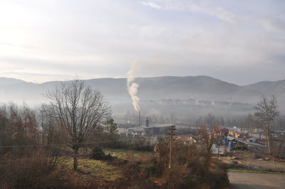 Smoke emitting from chimney against sky