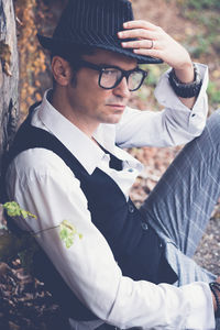 Side view of thoughtful mature man looking away while sitting outdoors