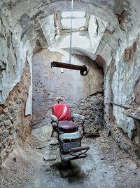 Abandoned shopping cart against wall in building