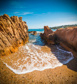 Rocks on beach against sky