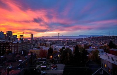 High angle view of street and buildings against sky during sunset