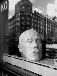 Close-up of statue against buildings in city