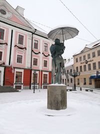 Statue in city against clear sky during winter