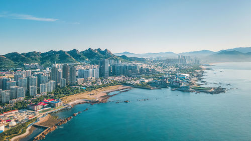 High angle view of city by sea against sky