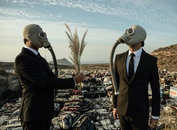 Mature men wearing gas mask standing outdoors