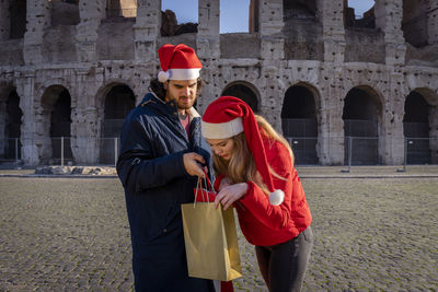 Christmas shopping time in rome. young couple checks the newly bought gifts.