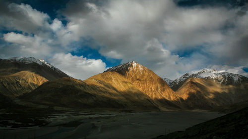Scenic view of mountains against cloudy sky