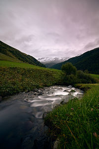 Scenic view of river amidst mountains against sky