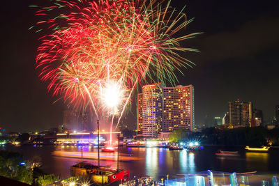 Firework display over river at night