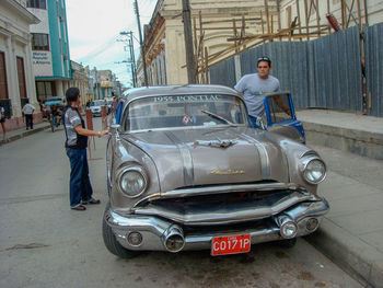 People standing on car on city street