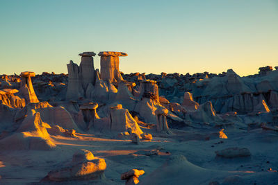 Built structure on land against clear sky during sunset