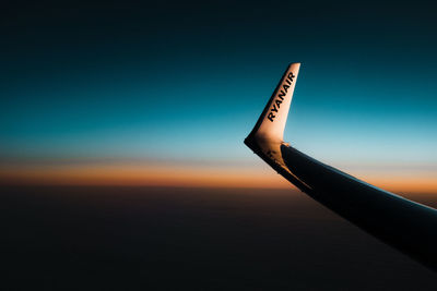 Airplane wing against clear sky