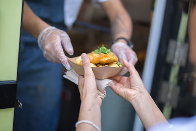 Street food- fried fish and chips served in a small paperboard.