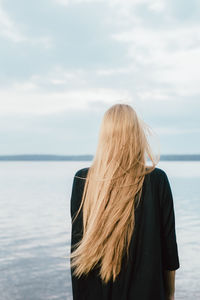 Rear view of woman looking at sea against sky