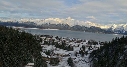 High angle view of townscape and snowcapped mountains against sky