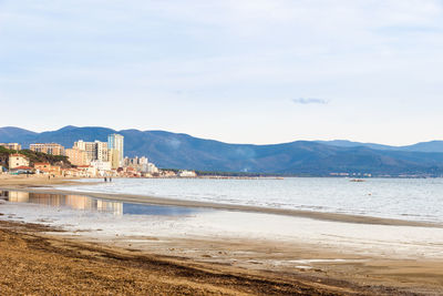 Scenic view of sea by city against sky