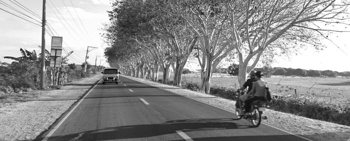 Rear view of woman walking on road