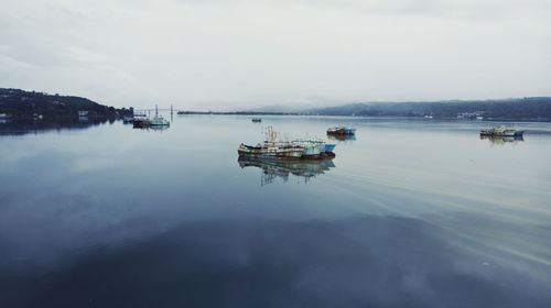 Fishing boats in sea against sky
