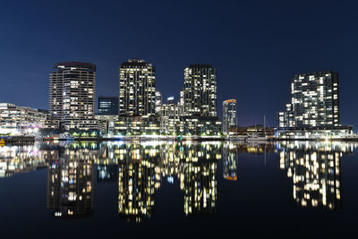 Reflection of illuminated buildings in city at night