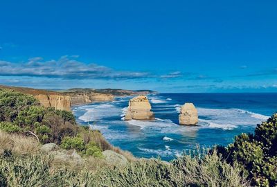 Scenic view of rocks in sea against blue sky