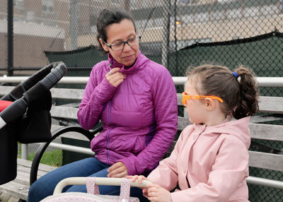 Mom and daughter enjoing a day on the boardwalk with baby strollers, toy and real