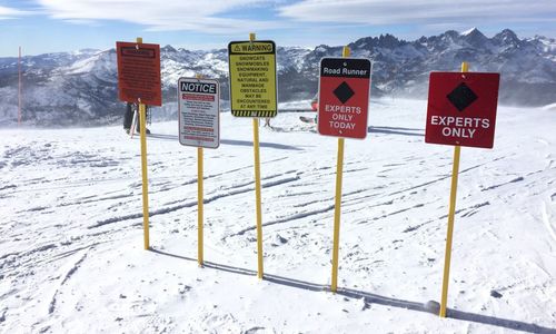 Warning sign on wooden post