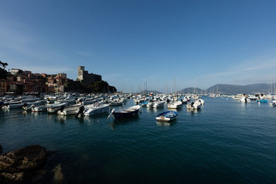 Harbor with boats against clear sky