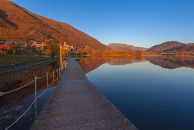 Small village overlooking the lake during an autumn sunset seen from wooden pier