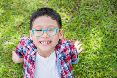 Directly above portrait of boy sitting on field