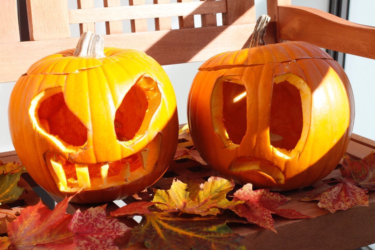 CLOSE-UP OF PUMPKIN ON TABLE AGAINST ORANGE AUTUMN LEAVES