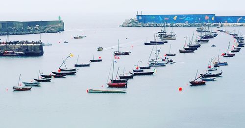 High angle view of sailboats moored in sea against sky