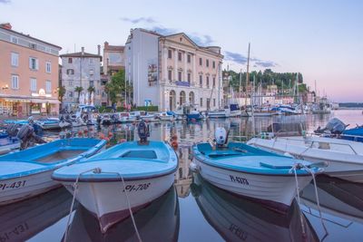 Boats moored in water against sky