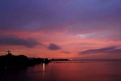 Scenic view of sea against dramatic sky during sunset