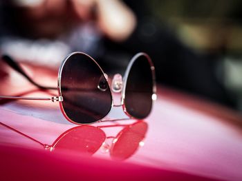 Close-up of sunglasses on pink table