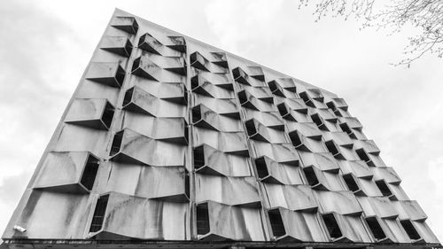 Low angle view of brutalist building against sky