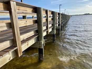 Wooden pier on sea against sky