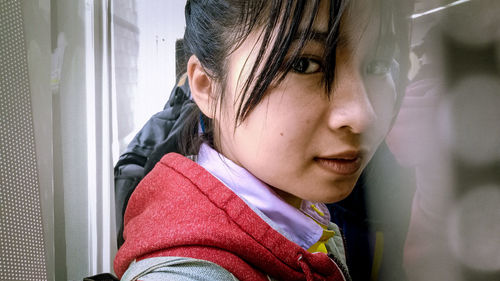 Portrait of woman looking through window