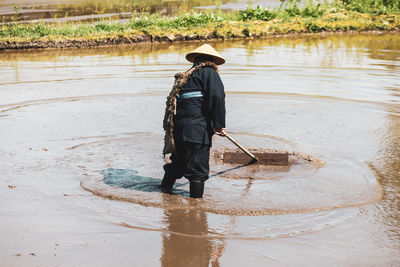 Rear view of man standing in water