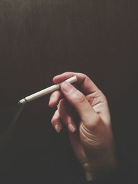 Cropped hand holding cigarette