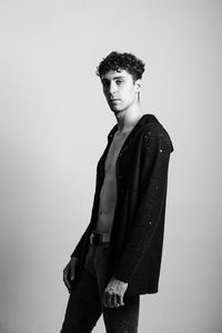 Handsome young man standing against gray background