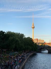 Fernsehturm by river against sky 