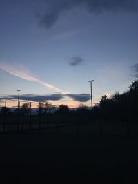 Scenic view of field against cloudy sky at sunset