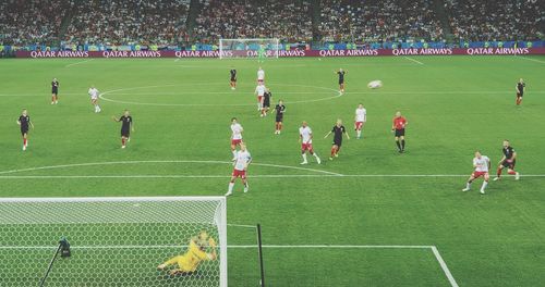 Group of people playing soccer on field