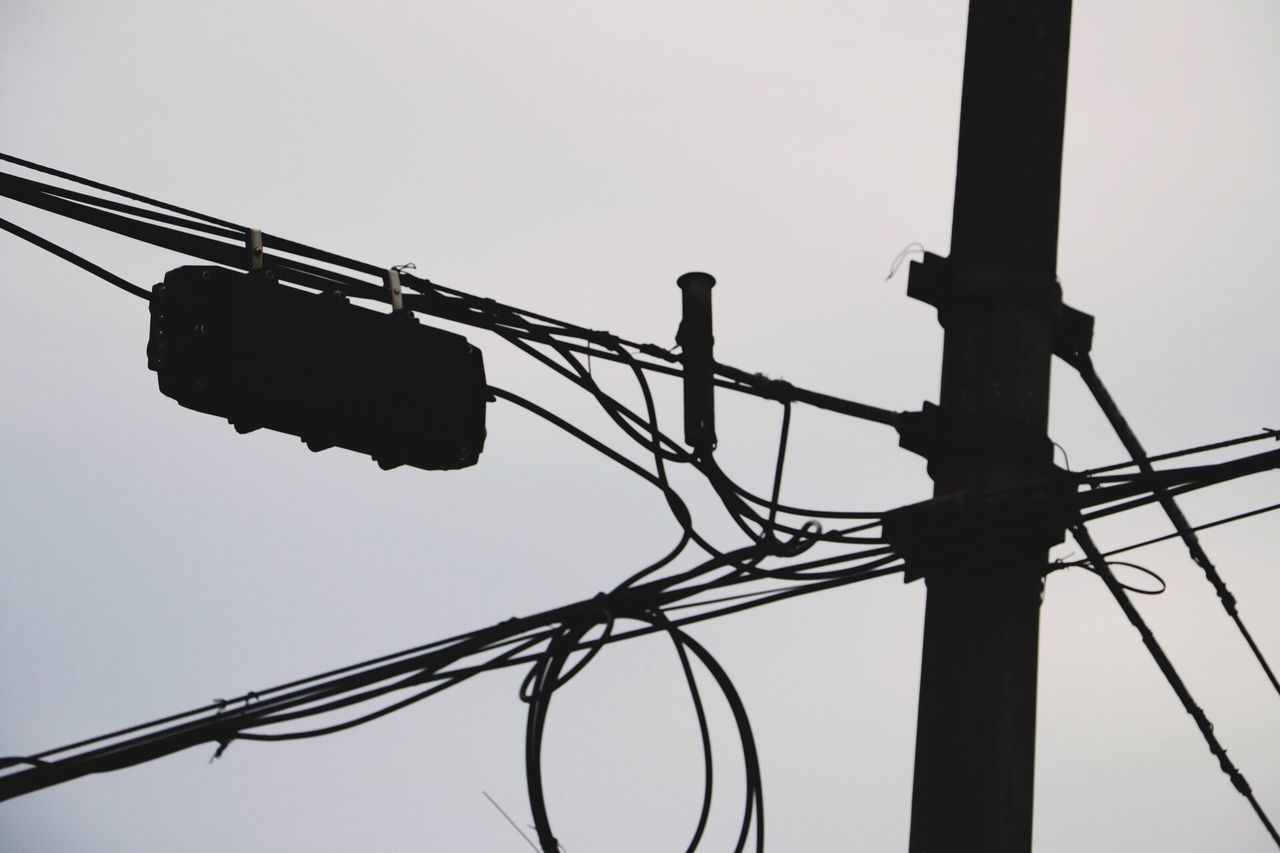 low angle view, power supply, cable, electricity, power line, sky, connection, no people, silhouette, outdoors, electricity pylon, clear sky, complexity, technology, day