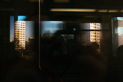 Reflection of silhouette buildings on glass window