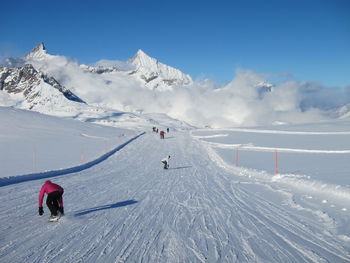 People skiing on snowcapped mountain