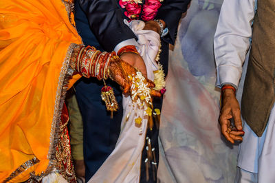 Midsection of couple performing rituals in wedding ceremony