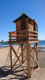 Built structure on beach against clear blue sky