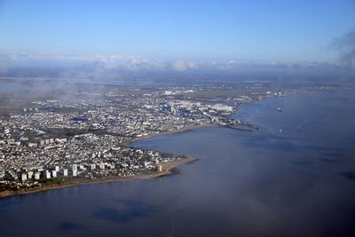 High angle view of townscape by sea against sky